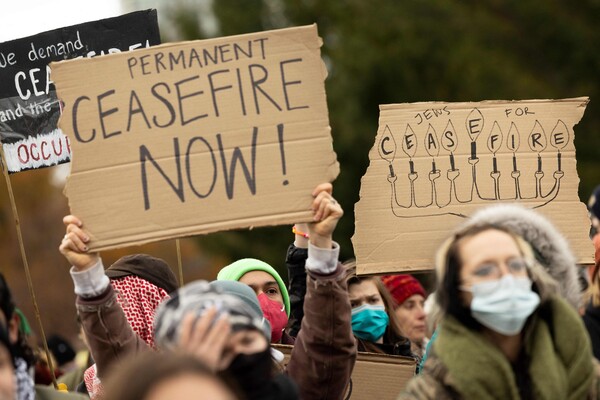 지난해 12월 11일(현지시간) 미국 펜실베이니아주 필라델피아 시내에서 조 바이든 대통령의 방문에 반대하는 시위대가 이스라엘과 팔레스타인 하마스 간 휴전을 촉구하는 종이 팻말을 들고 행진하고 있다. 미국은 최근 이스라엘-팔레스타인 전쟁 휴전을 위한 안보리 결의안을 부결시켰다. 2023.12.12 AFP 연합뉴스