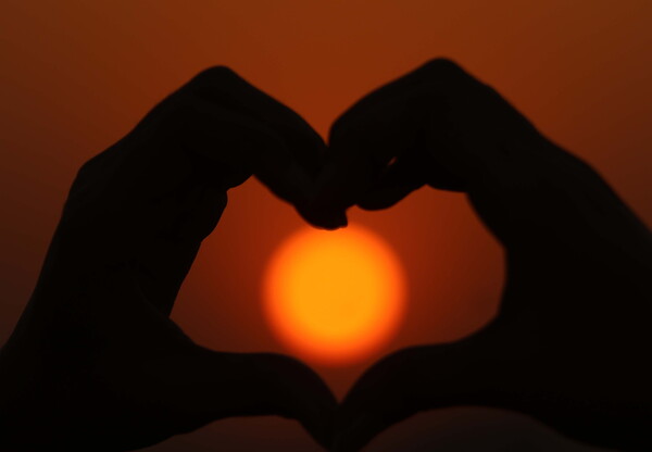 파키스탄 카라치에서 새해 전야의 석양을 배경으로 하트 모양을 만들고 있다.2023. 12. 31 [EPA=연합뉴스]