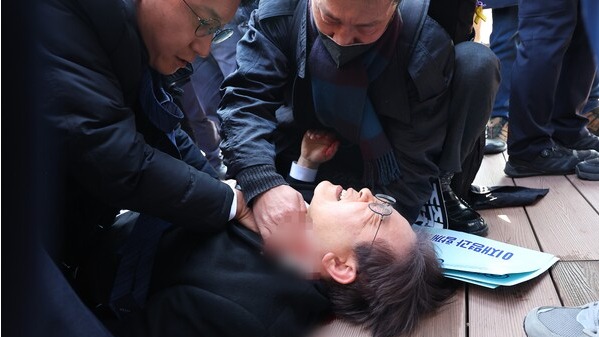 더불어민주당 이재명 대표가 2일 오전 부산 강서구 가덕신공항 부지를 둘러본 뒤 왼쪽 목 부위 피습을 당해 바닥에 누워 병원 호송을 기다리고 있다. 2024.1.2. 연합뉴스