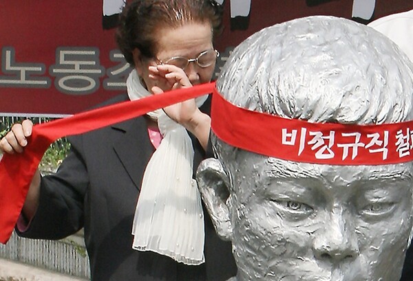 노동절인 1일 서울 평화시장 앞 '전태일 다리'에서 열린 '전태일 열사 정신계승 결의대회'에서 전태일 열사의 어머니 이소선씨가 전태일 열사 동상에 머리끈을 매어주던 도중 눈물을 닦고 있다./김주성/사회/2006.5.1 연합뉴스 자료사진