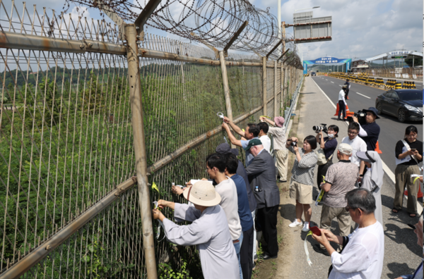한국전쟁 정전협정 70주년인 27일 경기도 파주시 통일대교 남단에서 시민사회단체 대표자들이 한반도 평화 선언문을 낭독한 뒤 철책에 평화를 기원하는 리본을 달고 있다. 2023.7.27. 연합뉴스 