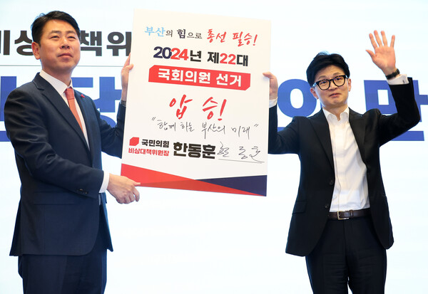 국민의힘 한동훈 비상대책위원장이 10일 오후 부산 벡스코에서 열린 부산 당원과의 만남에서 전봉민 부산시당위원장과 함께 총선 압승 서명판에 서명한 후 손을 흔들고 있다. 2024.1.10. 연합뉴스