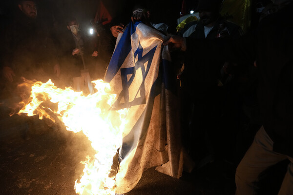12일 이란의 수도 테헤란 주재 영국 대사관 앞에서 전날 미국 영국 군의 예멘 후티 반군 군사거점 공습에 항의하며 이스라엘 국기를 태우는 이란의 항의시위자들.  2024.1.12. AP 연합뉴스