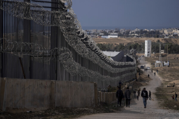 이스라엘의 폭격으로 난민으로 전락한 팔레스타인인들이 14일 가자 남부의 라파에서 이집트 국경 장벽을 따라 걷고 있다. 2024. 01. 14 [AP=연합뉴스]