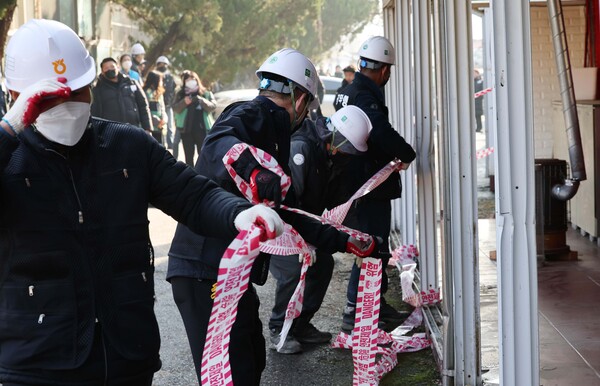 경기 파주시가 2023년 11월 22일 업주와 종사자들의 반발에도 성매매 업소 집결지인 파주읍 연풍리 이른바 '용주골'의 법규 위반 건축물에 대한 강제 철거에 나선 가운데, 철거 용역 업체 직원들이 통유리를 철거하고 '위험' 글자가 새겨진 테이프를 치고 있다. 2023.11.22. 연합뉴스