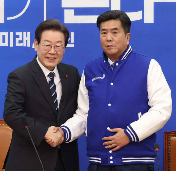 더불어민주당 이재명 대표가 27일 국회에서 열린 영입인재 환영식에서 강청희 전 대한의사협회 상근부회장에게 점퍼를 입혀주고 포즈를 취하고 있다. 2023.12.27. 연합뉴스