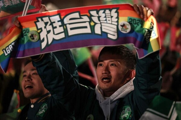 민진당 지지자들이 성소수자의 권리를 상징하는 무지개 모양의 깃발을 들고 있다 - 13일 대만 타이베이 민진당 당사 앞에서 지지자들이 환호하고 있다. 타이베이/AFP 연합뉴스.