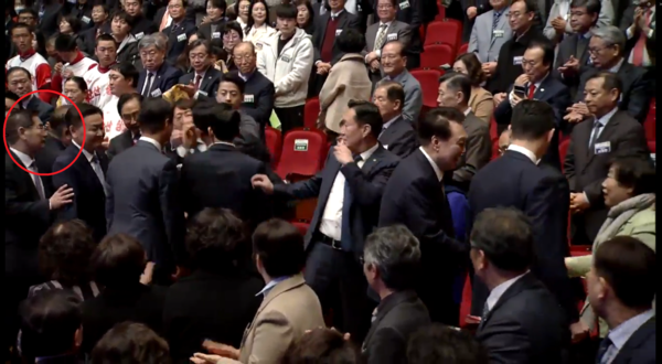 지난 18일 전북 전주에서 열린 전북특별자치도 출범식에서 진보당 강성희 의원이 대통령실 경호처 직원에 의해 강제로 끌려나가는 모습. 김용현 경호처장이 경호원에 의해 입을 틀어막히고 제압당하는 강 의원 방향을 바라보고 있다(빨간색 동그라미). 이후 김 처장은 강 의원을 향해 손으로 내려친다. 경호처는 경호원의 어깨를 쳤다는 입장으로 전해진다. 2024.1.19. 대통령실 영상 갈무리