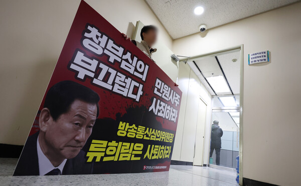 15일 방송통신심의위원회 직원이 민원인의 개인정보를 유출했다는 고발과 관련해 경찰 수사관들이 서울시 목동 방송회관 방송통신심의위윈회 민원상담팀 등을 압수수색 하는 중에 노조원이 류희림 위원장의 사퇴를 촉구하는 팻말을 들고 있다. 2024.1.15 연합뉴스