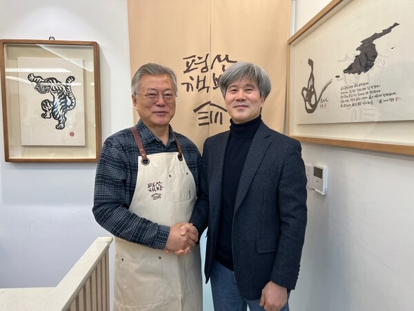 문재인 전 대통령이 지난 27일 경상남도 양산시 하북면 평산마을 평산책방에서 〈대통령의 마음〉 저자인 최우규 전 대통령 연설기획비서관과 악수하고 있다.