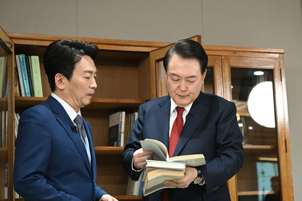 윤석열 대통령이 지난 4일 서울 용산 대통령실 청사에서 가진 KBS '특별대담 대통령실을 가다' 녹화를 마친 뒤 박장범 KBS 앵커에게 집무실에 설치한 부친 고(故) 윤기중 연세대 명예교수의 유품인 책장과 저서 '한국경제의 불평등 분석' 등을 소개하고 있다. 2024.2.7 [대통령실 제공. 재판매 및 DB 금지] 연합뉴스