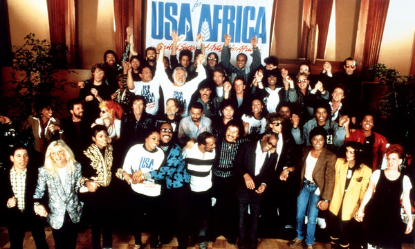 '위 아 더 월드' 녹음에 참여한 아티스트들 기념 사진. 맨 앞자리 중앙에 라이오넬 리치와 레이 찰스가 있고 해리 벨라폰테는 맨 뒷줄에 손을 들고 있다.