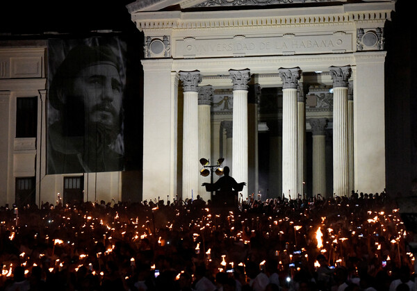 쿠바 수도 아바나에서 지난 1월 27일 독립영웅 호세 마르티의 탄생일을 맞아 젊은이들이 추념행사를 하고 있다. 건물 왼쪽에는 피델 카르스토의 초상화가 걸려 있다. 2024.1.27. 로이터 연합뉴스 
