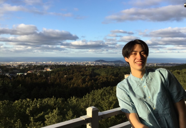 2022년 1월 3일 제주대 기숙사 옥상에서 웃으며 사진을 찍고 있는 김용희 씨 뒤로 제주시와 바다가 펼쳐진다. © 김용희 씨 제공