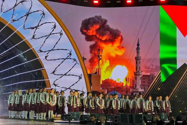 리비아 트리폴리에서 열린 무아마르 카다피 독재정권 타도 대중 봉기 13주년 기념식에서 어린이 합창단이 팔레스타인 국기를 배경으로 팔레스타인을 위한 노래를 부르고 있다. 2024. 02. 17 [AFP=연합뉴스]