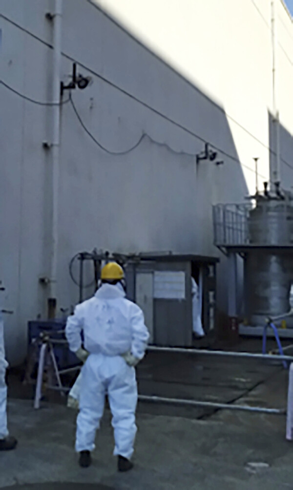지난 7일 도쿄전력 직원이 일본 후쿠시마 제1원전에서 방사성 물질이 누출된 통풍구를 검사하고 있다.  2024.2.7. AP 연합뉴스