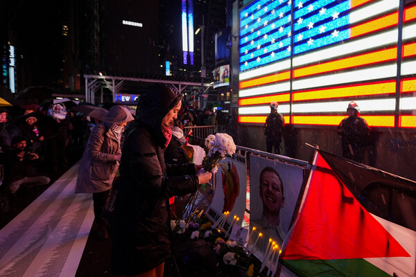 27일 ​미국 뉴욕의 모병센터 앞에서  열린 분신 미 공군 병사 애런 부시넬을 추모하는 촛불집회에서 한 참가자가 영정 앞에 조화를 놓고 있다. 2024.2.27. 로이터 연합뉴스 