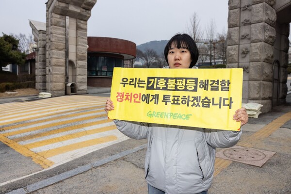 그린피스 청년 활동가가 정치권에 기후 불평등 해결을 촉구하는 배너를 들고 있다. [그린피스 제공]
