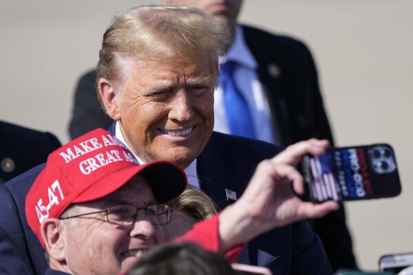 20일(현지시간) 미국 사우스캐롤라이나주 그리어 공항에 도착한 도널드 트럼프 전 대통령이 활짝 웃으며 지지자와 셀카를 찍고 있다. 이날 트럼프는 그린빌에서 열린 폭스뉴스 주최 타운홀 미팅 행사에 참석했다. 2024.02.21. AP 연합뉴스