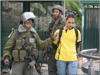 팔을 뒤로 묶인 채 무장한 이스라엘인에게 끌려가는 팔레스타인인. 미니