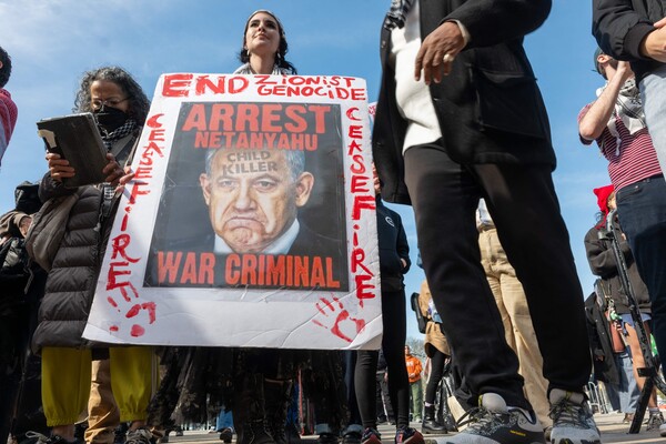 지난 13일 팔레스타인을 지지하는 활동가들이 뉴욕 브루클린에 모여 이스라엘의 가자지구 무력공격을 비난하는 시위를 벌이고 있다. 피켓에는 제노사이드(집단학살) 중단과 전쟁범죄자 네타냐후 체포, 휴전을 요구하는 글귀들이 적혀 있다. 2024.3.13. AFP 연합뉴스