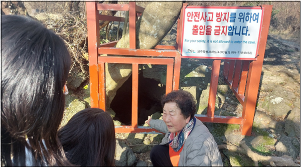 홍춘호 씨가 무등이왓 큰넓궤 앞에서 한미리스쿨 4.3취재진에게 당시 상황을 설명하고 있다. 큰넓궤는 길이가 180미터 정도 되는 크고 넓은 동굴인데 입구는 아이도 기어들어가야 할 만큼 비좁아 한동안 발각되지 않았다. © 이봉수