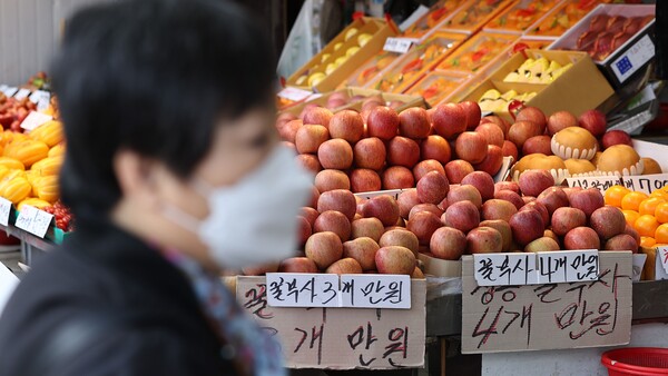 24일 사과 3~4개에 1만원 가격표가 붙어 진열돼 있는 서울 경동시장의 과일가게 앞을 한 시민이 지나가고 있다. 2024.3.24. 연합뉴스