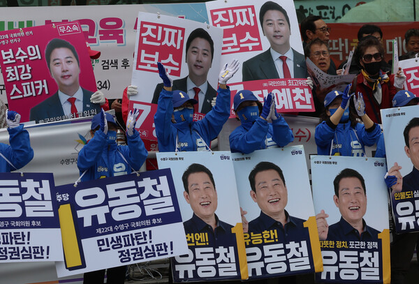 더불어민주당 이재명 대표가 부산 수영구를 찾은 4일 오후 선거운동원들이 유동철 후보와 무소속 장예찬 후보의 홍보 피켓을 나란히 들고 있다. 2024.4.4. 연합뉴스