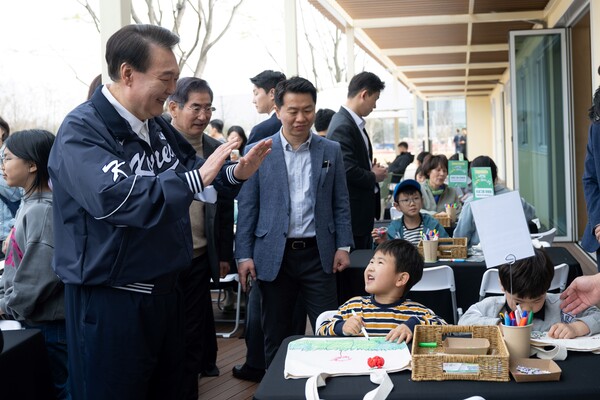 윤석열 대통령이 6일 서울 용산어린이정원 내 분수 정원의 잼잼카페에서 열린 에코백 만들기 프로그램을 참관하며 참가 어린이와 인사하고 있다. 2024.4.6. [대통령실 제공. 재판매 및 DB 금지] 연합뉴스