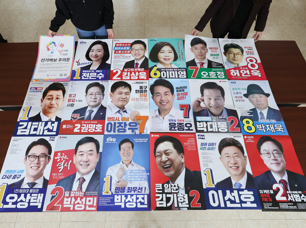 제22대 국회의원 선거 벽보 제출 마감일인 27일 오후 울산시 중구 울산시선거관리위원회에서 관계자들이 각 후보의 선거 벽보를 살펴보고 있다. 2024.3.27. 연합뉴스