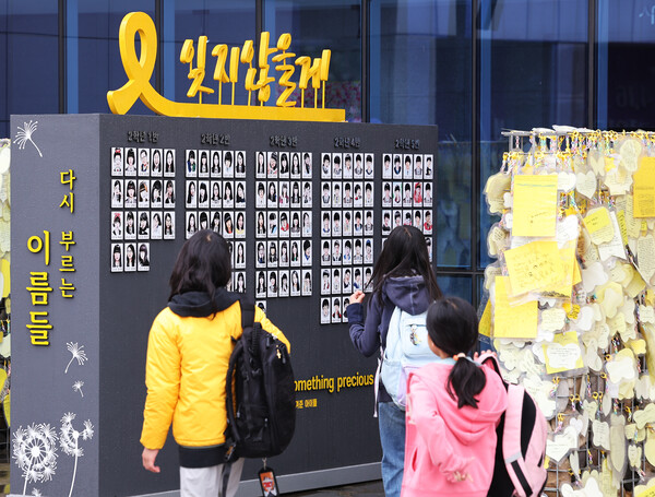 세월호 참사 10주기를 하루 앞둔 15일 오전 경기도 안산시 단원고 4.16기억교실을 찾은 추모객들이 외부에 설치된 참사 희생 학생들 캐리커처를 살펴보고 있다. 2024.4.15. 연합뉴스