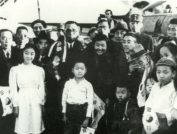 1945년 해방을 맞아 고국으로 돌아오기 위해 중국 상하이 공항에 모인 임시정부 요인들. 꽃다발을 목에 걸고 가운데 서 있는 인물이 김구, 오른쪽에 중절모를 쓰고 손으로 눈물을 닦는 인물이 신흥대학 설립자 이시영, 김구 앞에 선 소년이 이시영의 종손자 이종찬이다. [우당기념관 제공]