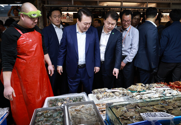 윤석열 대통령이 10일 오후 서울 서대문구 영천시장을 찾아 수산 매장에서 상인과 대화하며 수산물을 살피고 있다. 윤 대통령 오른쪽은 김주현 대통령실 민정수석비서관. 2024.5.10. 연합뉴스