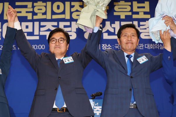 더불어민주당 국회의장 후보로 선출된 우원식 후보(왼쪽)와 국회부의장 후보로 선출된 이학영 후보가 16일 오전 국회 의원회관에서 열린 제22대 전반기 국회의장단 후보 선출을 위한 당선자 총회에서 꽃다발을 들고 두 팔을 들어 올리고 있다. 2024.5.16. 연합뉴스