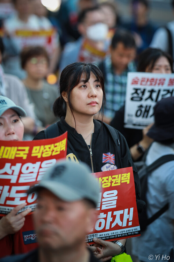18일 서울 시청역 앞 대로에서 열린 촛불대행진에 참가한 한 시민이 발언자의 말을 들으며 생각에 잠겨 있다. 이호 작가