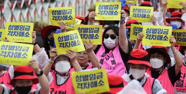 '성별 임금 격차 해소'는커녕 오히려 더 커지고 있다. 지난해 6월 전국여성노동조합 관계자들이 서울 용산구 대통령 집무실 인근에서 열린 최저임금 인상 촉구 집회에서 팻말을 들고 시위를 하는 모습. 연합뉴스