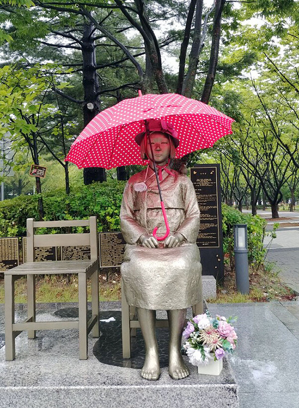 장마전선의 영향으로 호남, 충청, 경기 남부에 많은 비가 내린 1일 대전시 서구 보라매공원에 설치된 평화의 소녀상에 우산이 씌워져 있다. 보라매공원을 산책하던 시민이 씌운 것으로 보인다. 2018.7.1. 연합뉴스