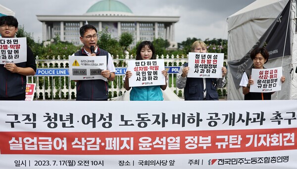 지난해 7월 국회 앞에서 열린 ‘실업급여 삭감·폐지 윤석열 정부 규탄 기자회견’에서 민주노총 관계자들이 관련 손피켓을 들고 있다. 2023.7.17 연합뉴스
