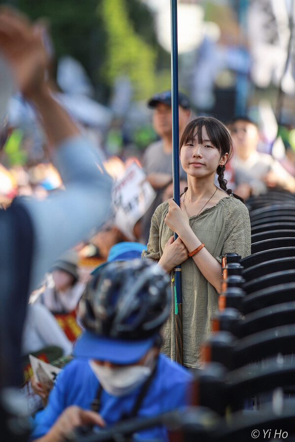 1일 오후 서울 시청역~남대문 대로에서 열린 제92차 촛불 대행진 집회 도중 한 참가자가 깃대를 쥔 채 카메라를 바라보고 있다. 2024.6.1. 사진 이호 작가