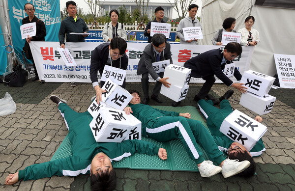 중소상인ㆍ금융소비자단체 회원들이 서울 여의도 국회 정문 앞에서 '가계부채 문제 해결 촉구' 기자회견을 마친 뒤 빚 탕감을 위한 정치권, 정부, 은행의 대책을 요구하는 내용의 퍼포먼스를 하고 있다. 2023.10.19. 연합뉴스