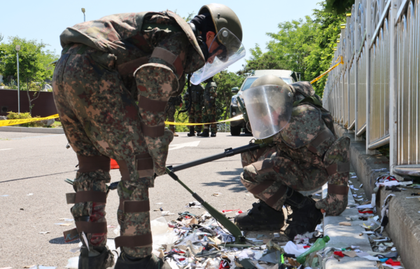 지난 6월2일 오전 인천 중구 전동 인천기상대 앞에 떨어진 북한 오물 풍선 잔해를 군 장병들이 지뢰 탐지기로 확인하고 있다. 연합뉴스