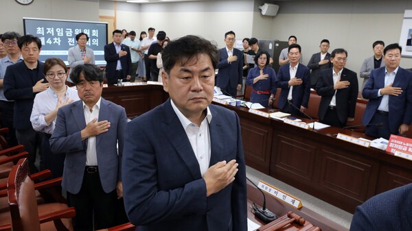 지난 13일 오후 정부세종청사 최저임금위원회에서 열린 제4차 전원회의에서 이인재 최저임금위원회 위원장을 비롯한 위원들이 국기에 경례하고 있다. 2024.6.13. 연합뉴스