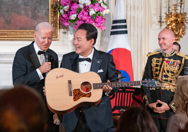 윤석열 대통령이 26일(현지시간) 백악관에서 열린 국빈만찬 특별공연에서 조 바이든 대통령으로부터 미국 싱어송라이터 돈 매클린의 친필 서명이 담긴 기타를 선물받고 있다. 2023.4.28 [공동취재] 연합뉴스