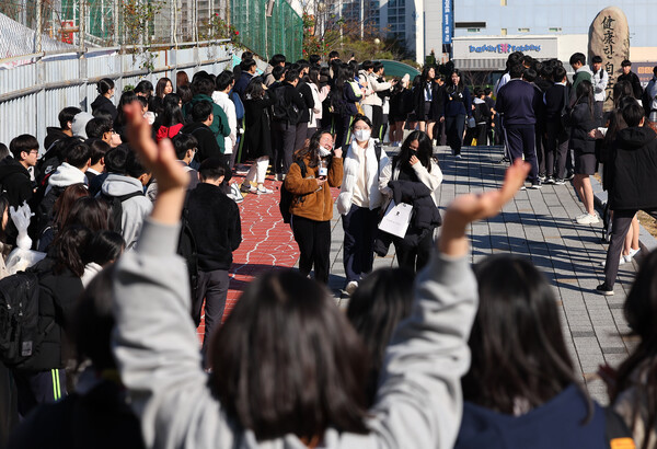 2024학년도 대학수학능력시험을 하루 앞둔 15일 오전 부산 해운대구 신도고등학교에서 고3 수험생들이 선생님과 후배들의 응원을 받으며 교정을 나서고 있다. 2023.11.15.. 연합뉴스
