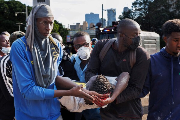 케냐 수도 나이로비 의회 의사당 근처에서 서민 증세안에 반대하는 항의 시위를 벌이던  한 시민이 경찰이 쏜 고무 총탄에 머리를 맞아 병원으로 옮겨지고 있다. 2024. 06. 25 [AFP=연합뉴스]