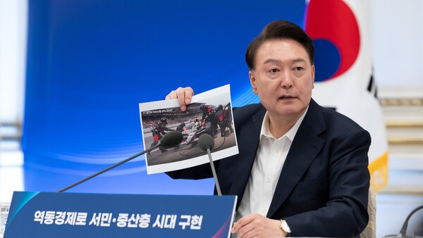 윤석열 대통령이 3일 서울 종로구 청와대 영빈관에서 열린 '하반기 경제정책방향 및 역동경제 로드맵 발표' 회의에서 F1 경주의 피트 스톱 사진을 들고 마무리 발언을 하고 있다. 2024.7.3 [대통령실 제공] 연합뉴스