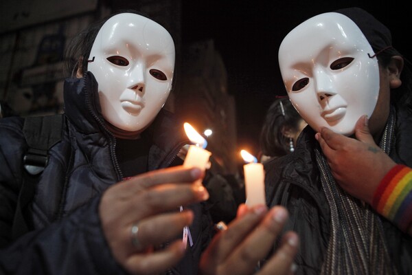 볼리비아 수도 라파즈에서 열린 국제 동성애 혐오 반대의 날 기념 시위에서 흰 가면을 쓴 참가자들이 촛불을 켜고 있다. 2011.5.17. AP=연합뉴스