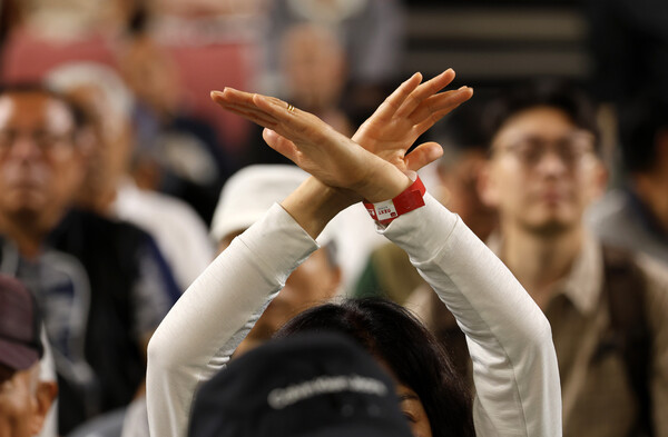 15일 오후 충남 천안 유관순체육관에서 열린 국민의힘 대전·세종·충북·충남 합동연설회에서 일부 참석자가 자신이 지지하지 않는 후보를 향해 손으로 'X'를 그리고 있다. 2024.7.15. 연합뉴스