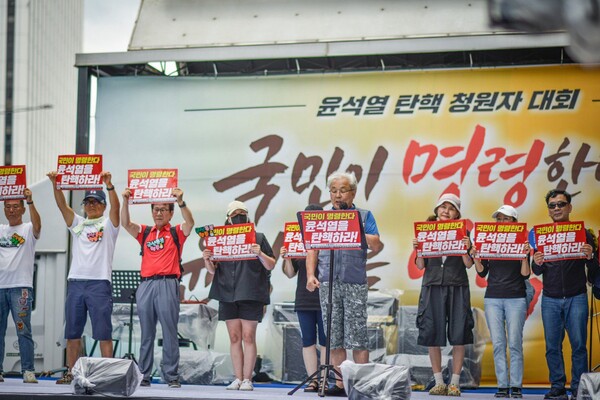 20일 서울 시청역~숭례문 앞 대로에서 열린 99차 촛불대행진 7월 전국집중촛불에 참가한 군산촛불행동 회원들의 모습. 남대진 공동대표가 발언을 하고 있다. 2024.7.20. 한국대학생진보연합 사진동아리 빛봄