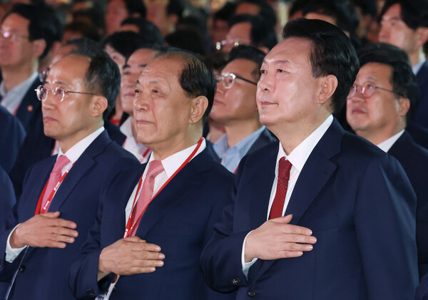 윤석열 대통령이 23일 오후 경기 고양시 킨텍스에서 열린 국민의힘 제4차 전당대회에 참석해 국기에 경례하고 있다. 오른쪽부터 윤 대통령, 황우여 비상대책위원장, 추경호 원내대표. 2024.7.23 [대통령실통신사진기자단] 연합뉴스